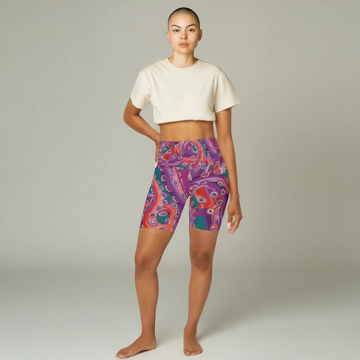 Model wearing Sea Dragon Dreams high waisted yoga shorts with a vibrant purple and red octopus pattern.
