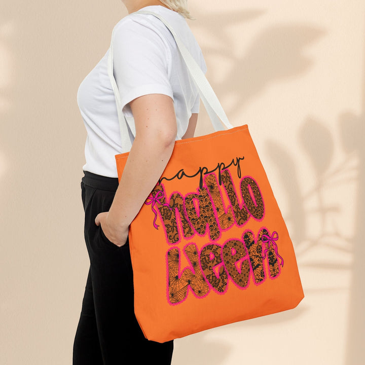Sea Dragon Dreams orange polyester tote bag with Happy Halloween text, worn over the shoulder by a person.