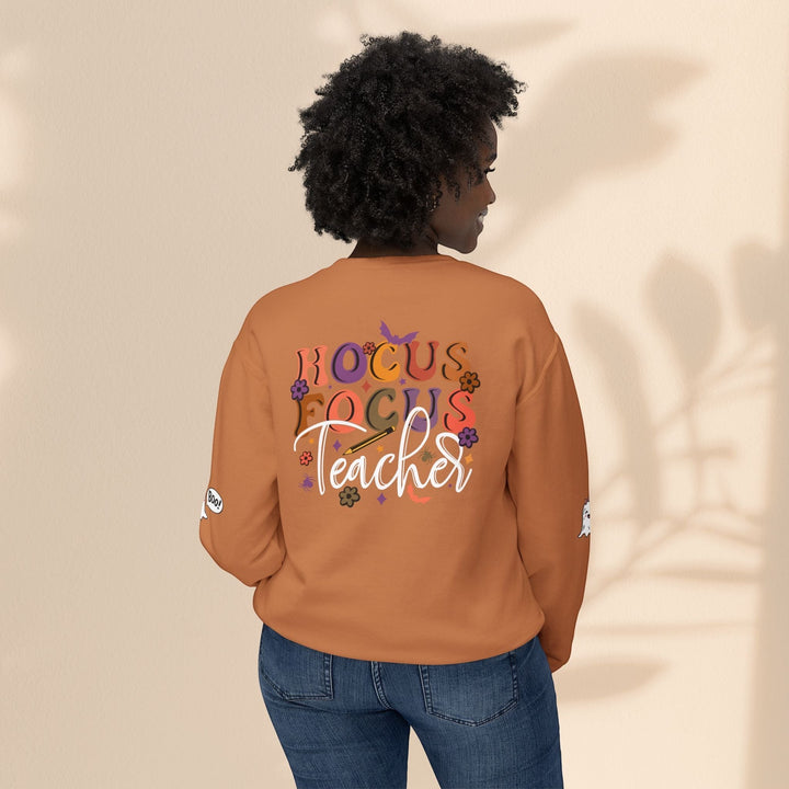 Sea Dragon Dreams unisex orange crewneck sweatshirt with Hocus Focus Teacher graphic on back, worn by a woman.