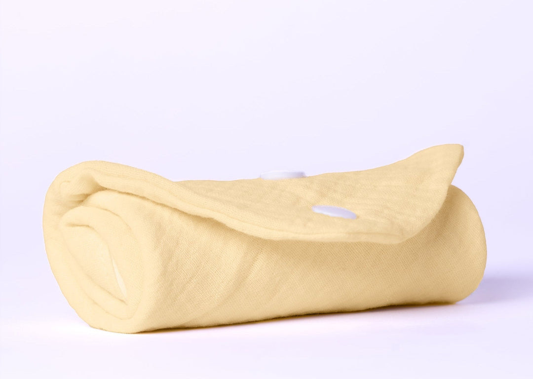 Sea Dragon Dreams soft pale yellow organic cotton baby burping cloth rolled up with white snap button closure
