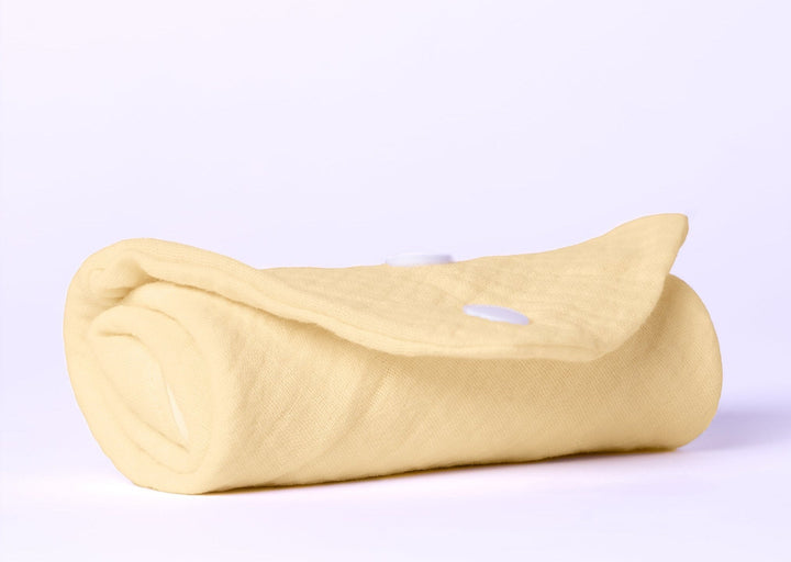Sea Dragon Dreams soft pale yellow organic cotton baby burping cloth rolled up with white snap button closure