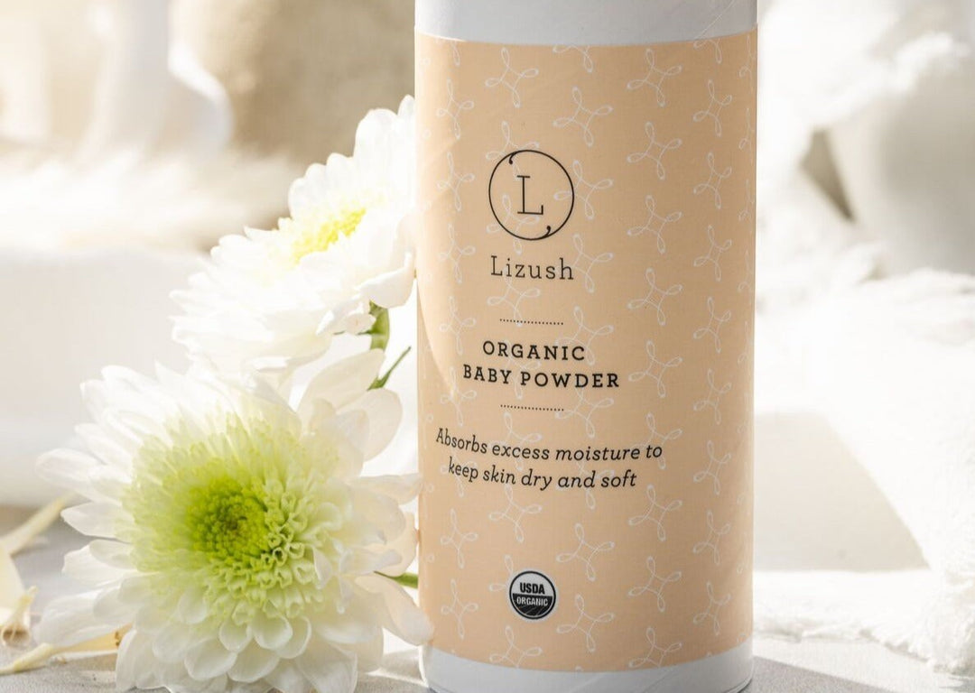 Sea Dragon Dreams organic baby powder in a peach-colored container with white floral accents