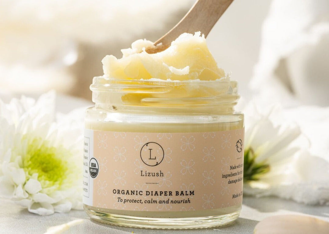 Sea Dragon Dreams organic diaper balm in a glass jar with a wooden scoop, featuring natural ingredients for baby skin.