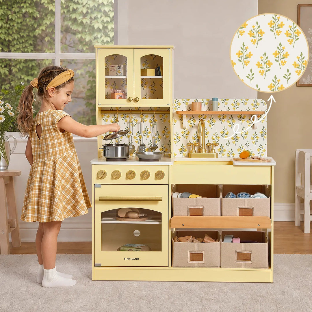 Sea Dragon Dreams Tiny Land wooden play kitchen in pale yellow with floral backsplash, storage bins, and accessories.