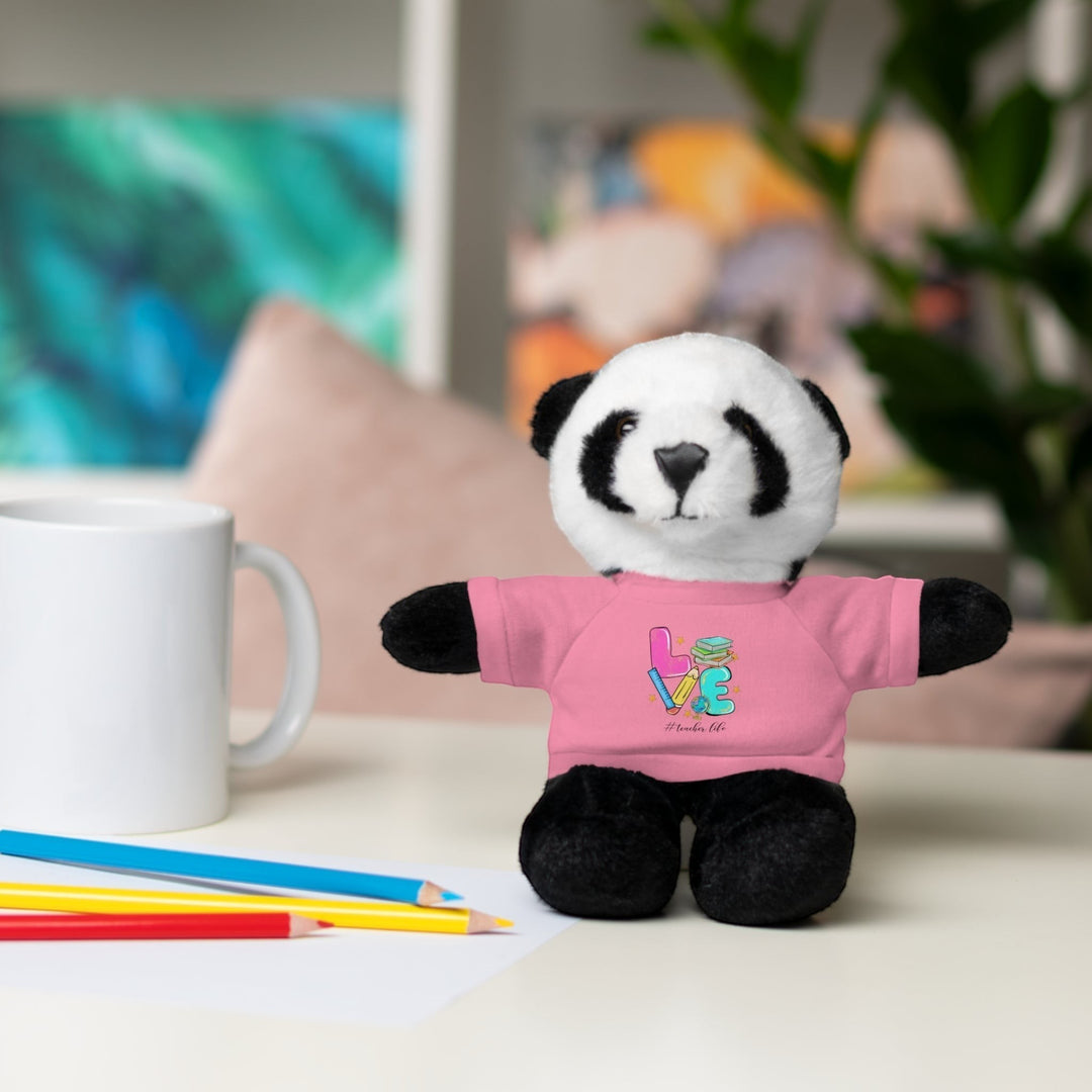 Sea Dragon Dreams panda stuffed animal wearing a pink cotton tee with Love Teacher Life graphic on a desk