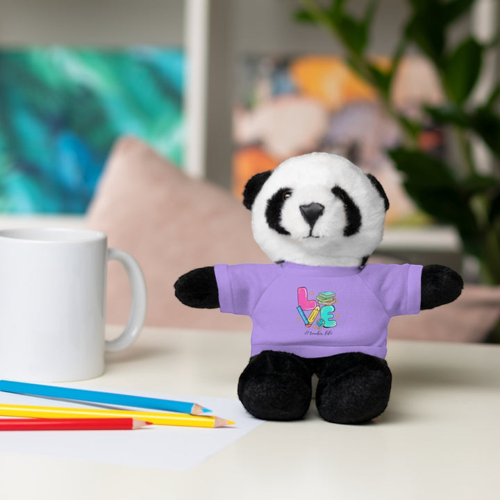 Sea Dragon Dreams panda plush toy wearing a purple t-shirt with Love Teacher Life design on a desk with pencils