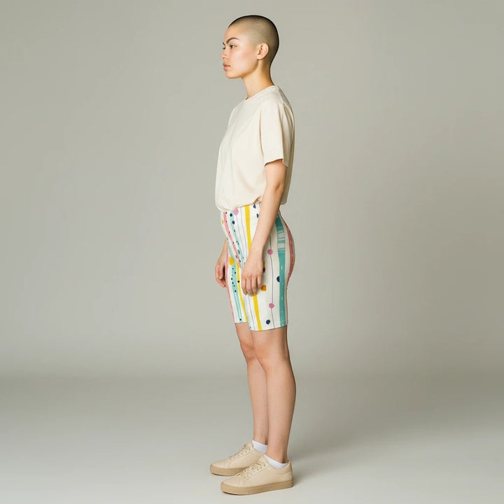 Sea Dragon Dreams high-waisted biker shorts with pastel stripes, polka dots, and brushstrokes on a model in profile.
