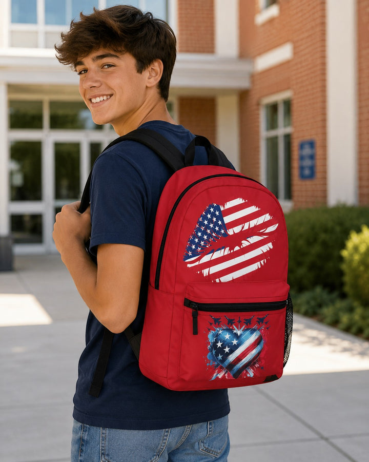 A young man wearing a Sea Dragon Dreams red polyester backpack with patriotic heart and USA flag designs outdoors.