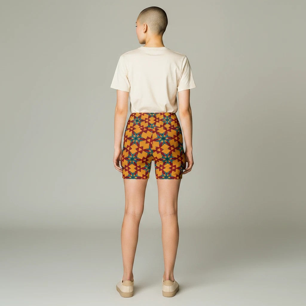 Model wearing Sea Dragon Dreams red and yellow patterned polyester workout shorts with a plain beige t-shirt