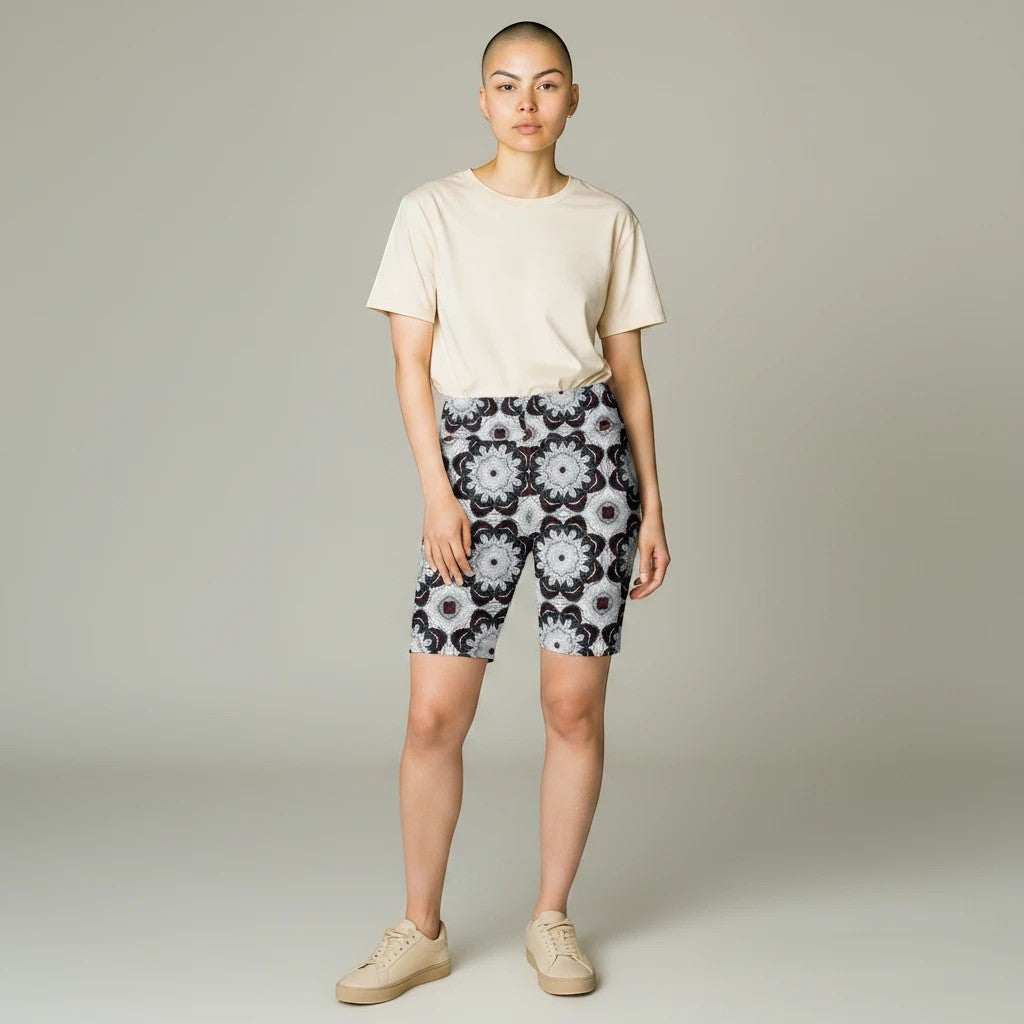 Model wearing Sea Dragon Dreams black and white patterned workout shorts with a beige t-shirt and sneakers.