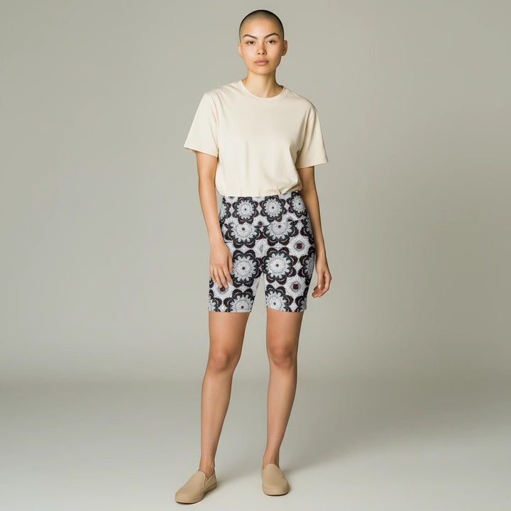 Model wearing Sea Dragon Dreams black and white patterned workout shorts with a beige t-shirt and slip-on shoes.