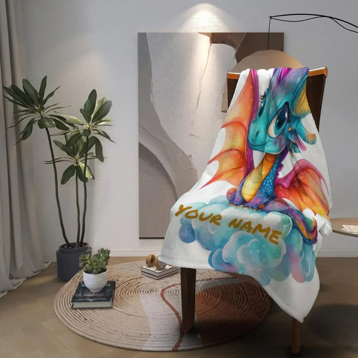 Sea Dragon Dreams personalized flannel fleece blanket featuring a colorful dragon on clouds, draped over a chair.