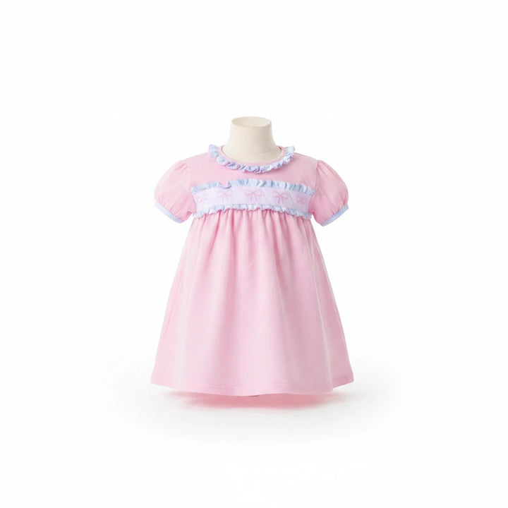 Sea Dragon Dreams pink baby dress with puff sleeves, ruffle trim, and bow-detail chest band on a mannequin