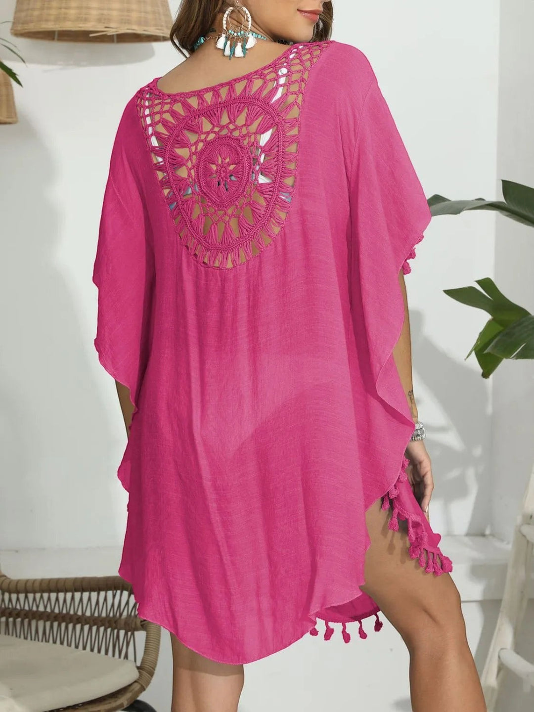 Sea Dragon Dreams hot pink crochet beach cover-up with intricate back cutout, round neck, and tassel hem details.
