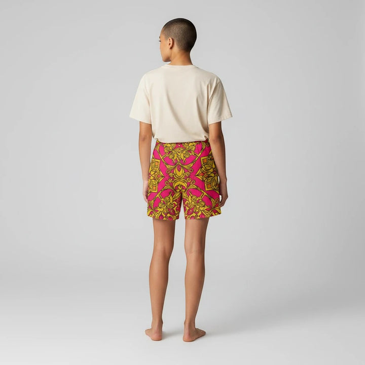 Sea Dragon Dreams women's bike shorts in pink and gold with a symmetrical floral print, worn with a cream t-shirt.