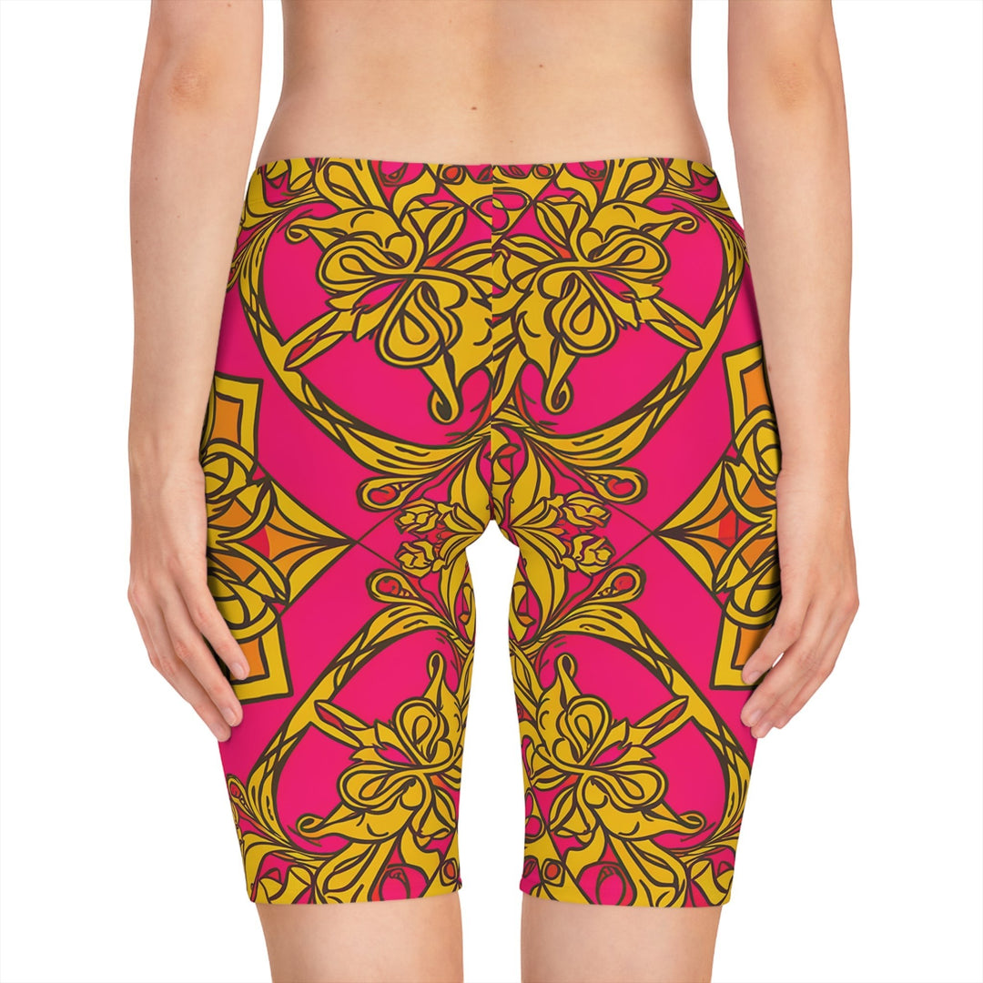 Sea Dragon Dreams women's bike shorts featuring a vibrant pink and gold symmetrical floral pattern in polyester blend