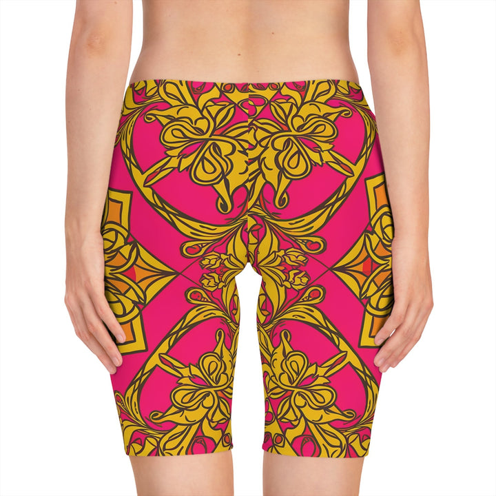 Sea Dragon Dreams women's bike shorts featuring a vibrant pink and gold symmetrical floral pattern in polyester blend