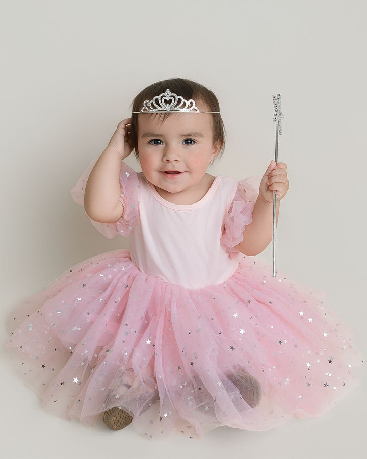 Sea Dragon Dreams Good Witch Dress featuring a pink bodice, puff sleeves, and a star-patterned tulle skirt on a girl.