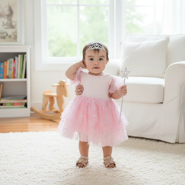 Sea Dragon Dreams toddler girl wearing a pink Good Witch costume with a star-patterned tulle skirt and puff sleeves.
