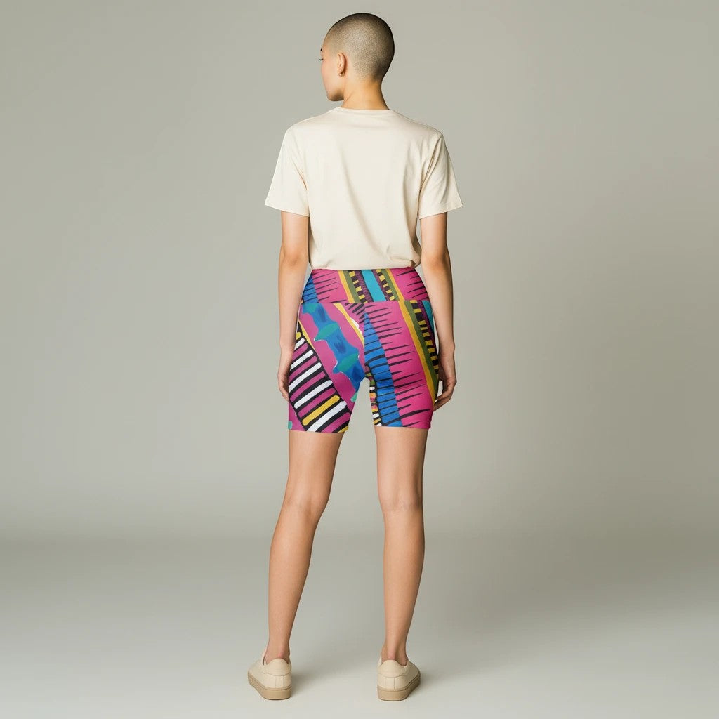Sea Dragon Dreams Pink Party workout shorts with vibrant geometric patterns worn by a model with a plain t-shirt.