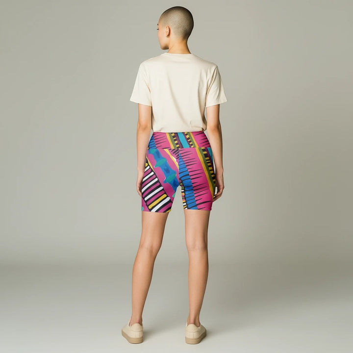 Sea Dragon Dreams Pink Party workout shorts with vibrant geometric patterns worn by a model with a plain t-shirt.