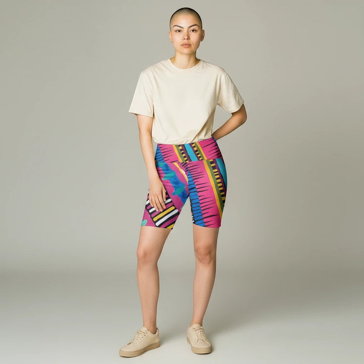 Model wearing Sea Dragon Dreams Pink Party workout shorts with vibrant geometric patterns and a mid-rise waistband.