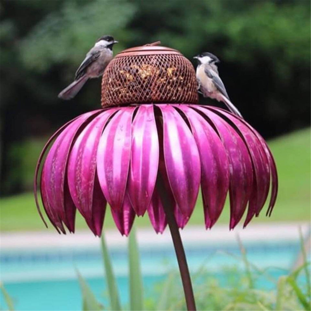 Sea Dragon Dreams petal-shaped metal bird feeder in vibrant pink with a mesh seed holder and two small birds perched.