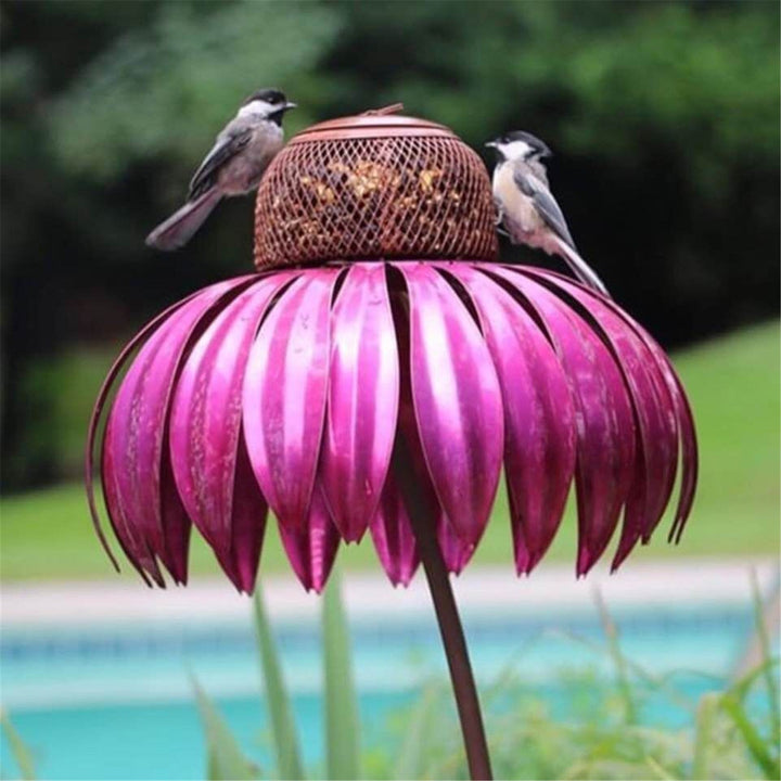 Sea Dragon Dreams petal-shaped metal bird feeder in vibrant pink with a mesh seed holder and two small birds perched.