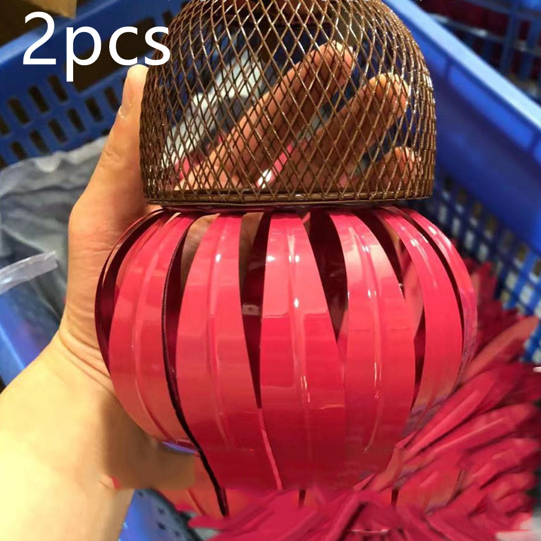 Sea Dragon Dreams petal-shaped bird feeder with a pink metal body and a brown mesh top held in a hand.