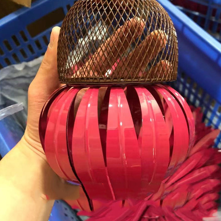 Sea Dragon Dreams petal-shaped bird feeder in bright pink with a bronze metal mesh top held in a hand