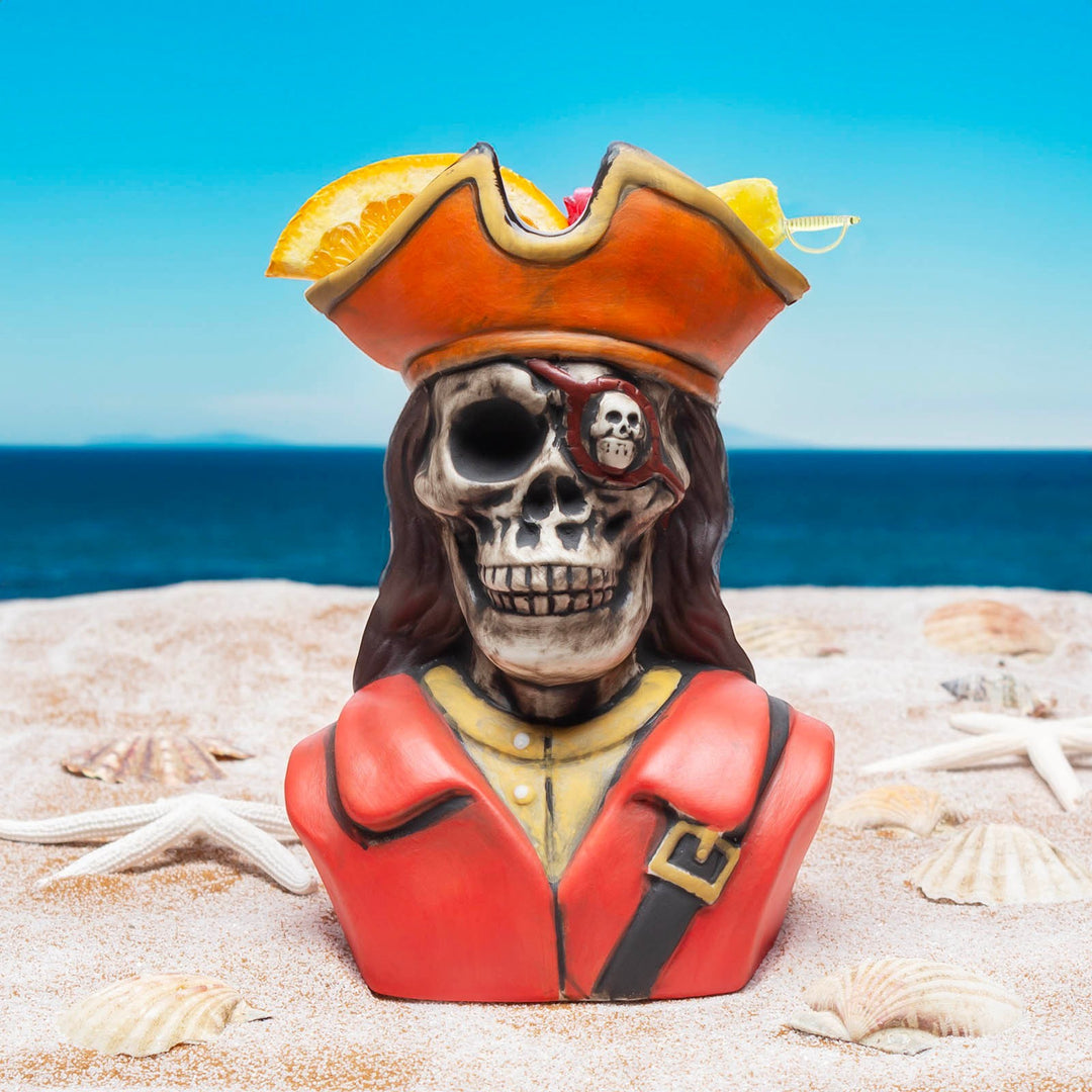 Sea Dragon Dreams pirate skeleton tiki mug, hand-painted ceramic drinkware on a sandy beach with ocean background.