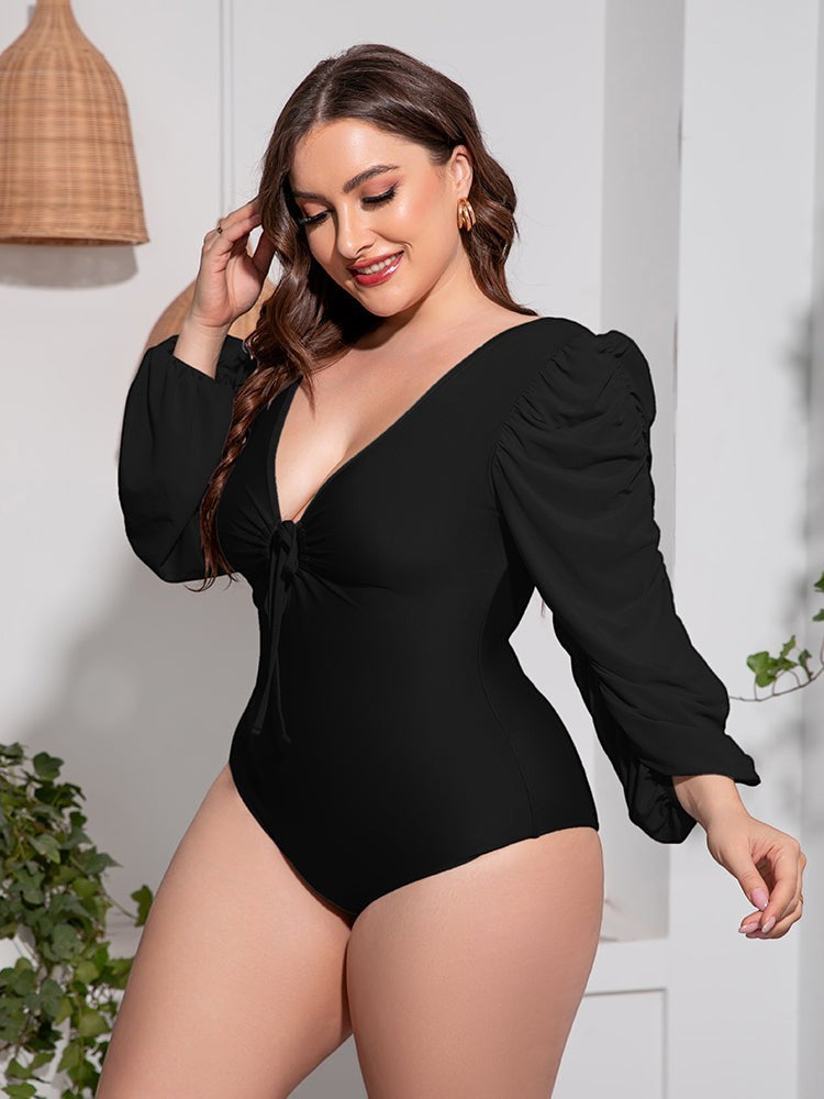 Sea Dragon Dreams plus size black one-piece swimsuit with a deep V-neck, tie front, and long balloon sleeves.