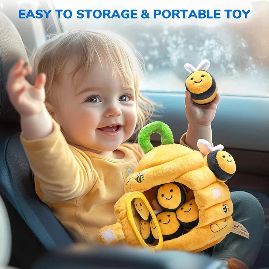 Sea Dragon Dreams soft plush beehive toy with five sensory bee rattles held by a happy baby in a car seat