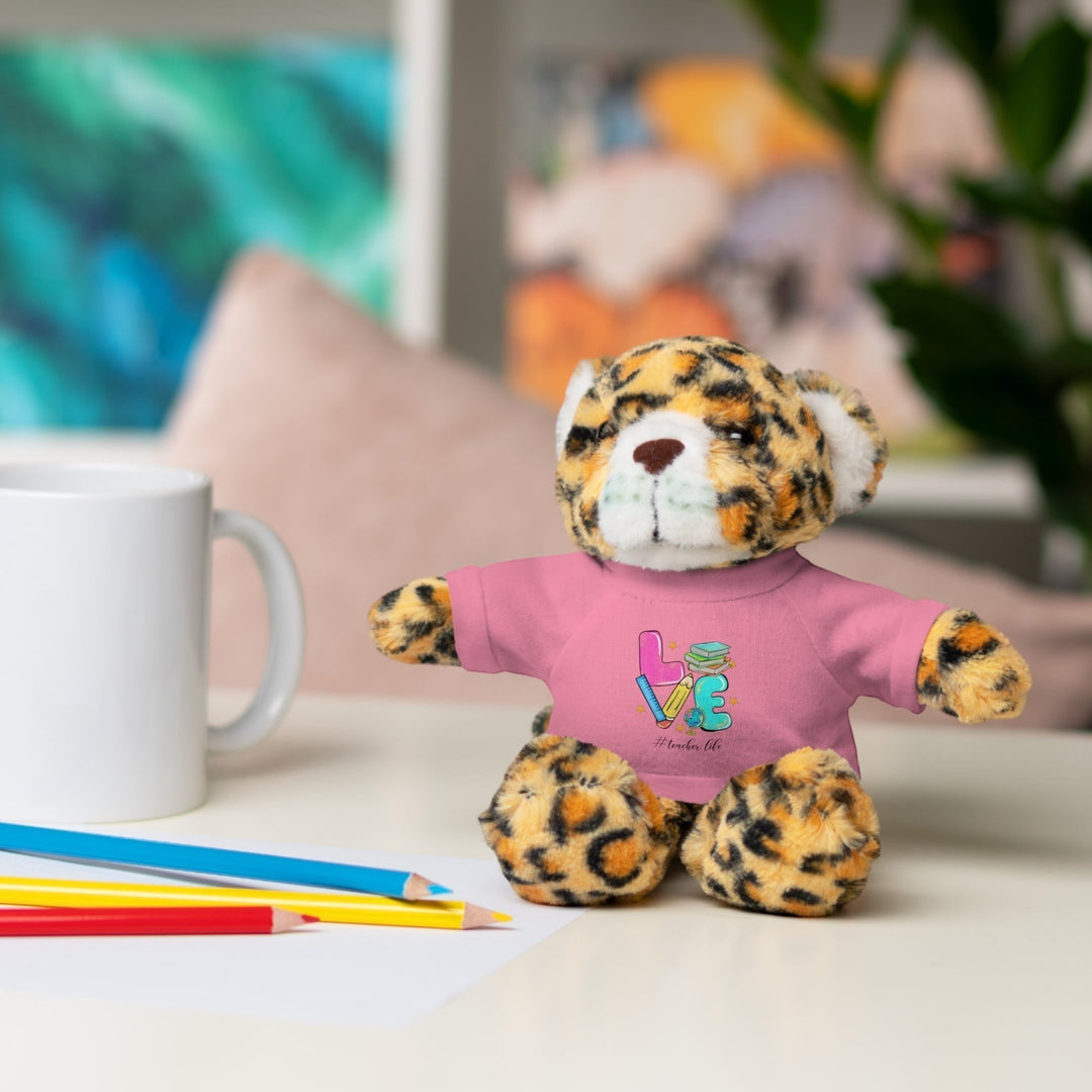 Sea Dragon Dreams plush jaguar stuffed animal wearing a pink t-shirt with Love Teacher Life text, sitting on a desk.