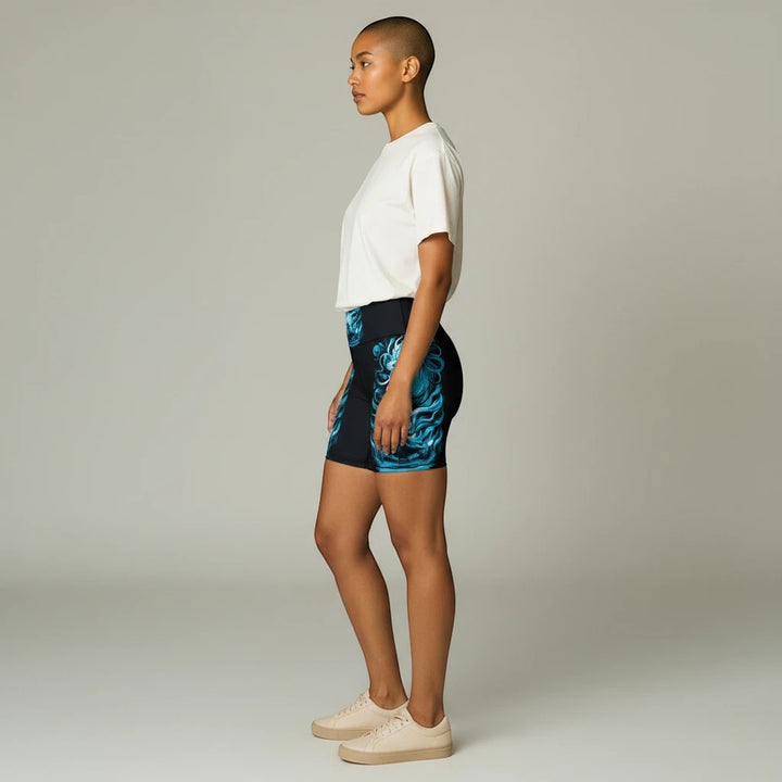 Sea Dragon Dreams women's workout shorts with a blue printed design on black polyester fabric, side view.