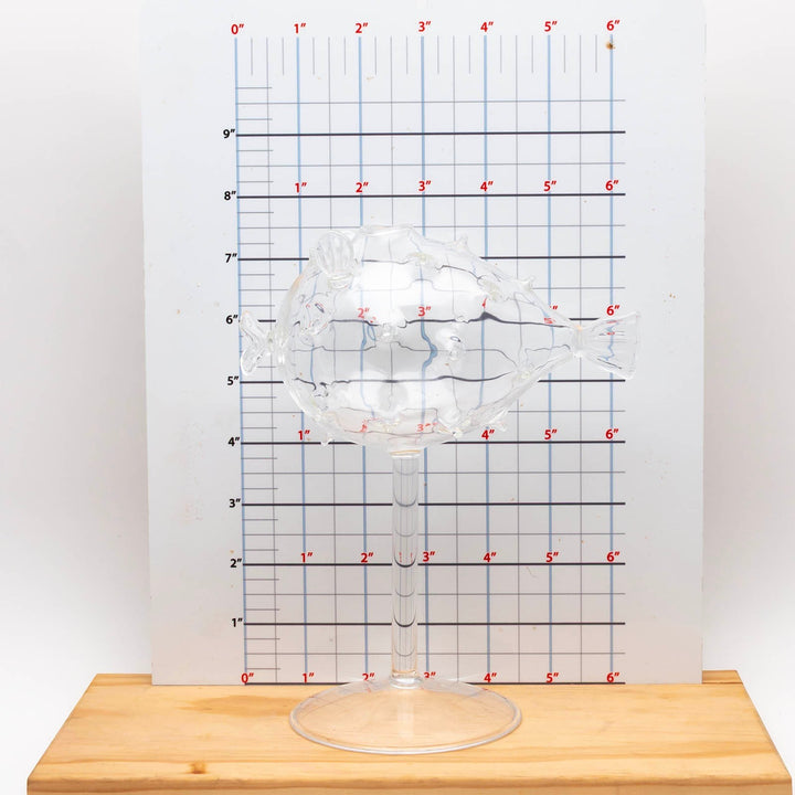Sea Dragon Dreams BarConic puffer fish cocktail glass with a clear stem and base against a measurement grid