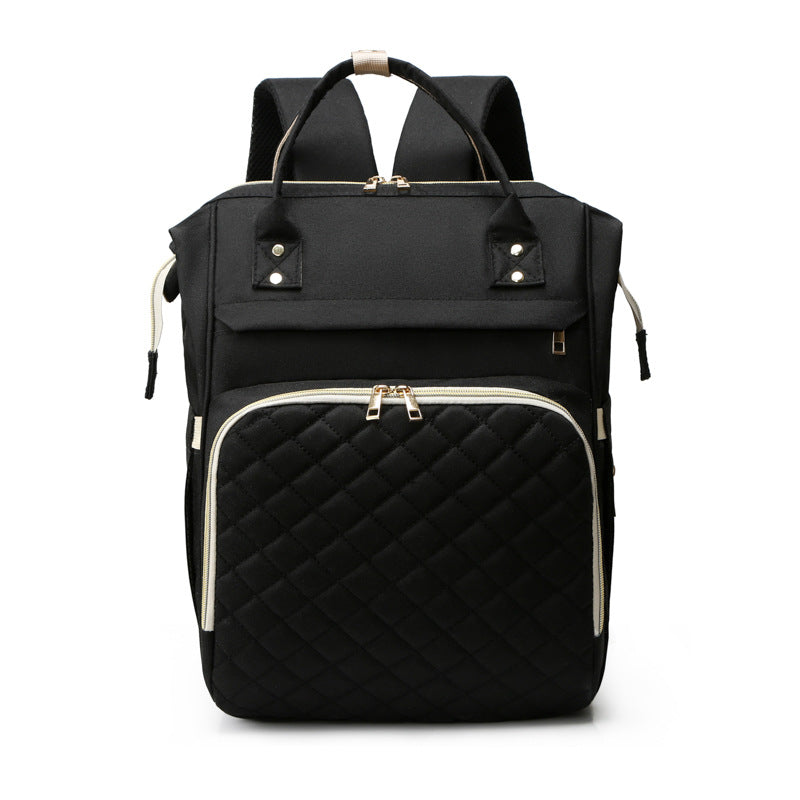 Sea Dragon Dreams black multifunctional diaper backpack with a quilted front pocket and gold zipper details.