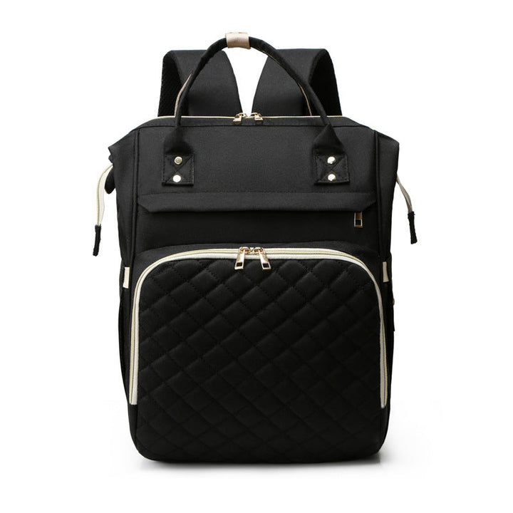 Sea Dragon Dreams black multifunctional diaper backpack with a quilted front pocket and gold zipper details.