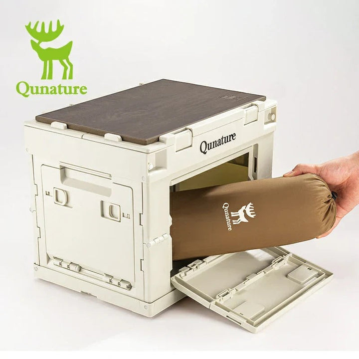 Sea Dragon Dreams Qunature self-inflating pillow in a brown storage bag being placed into a beige folding storage crate