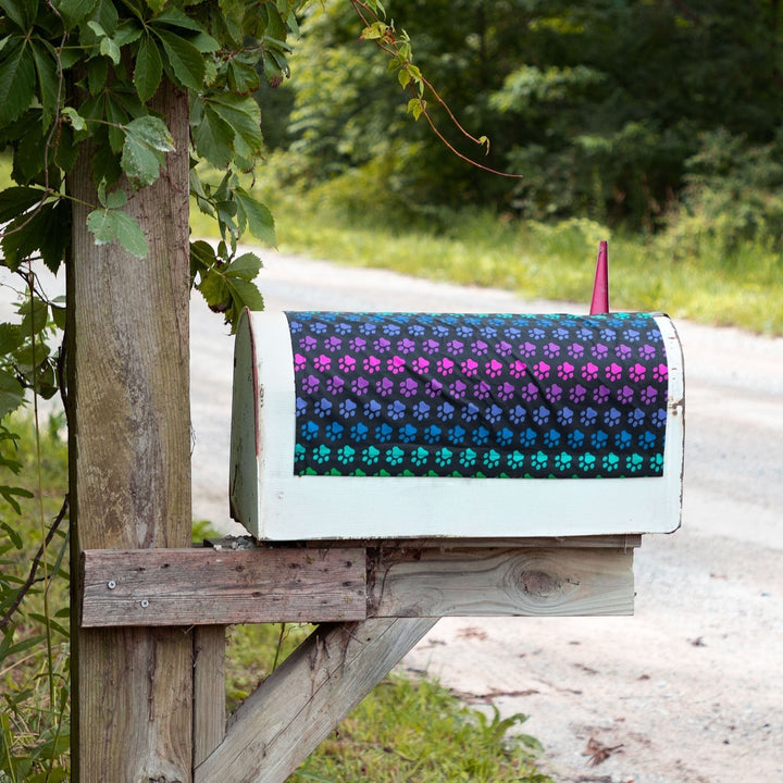 Sea Dragon Dreams magnetic mailbox cover featuring a vibrant rainbow paw print pattern on a black fabric background.