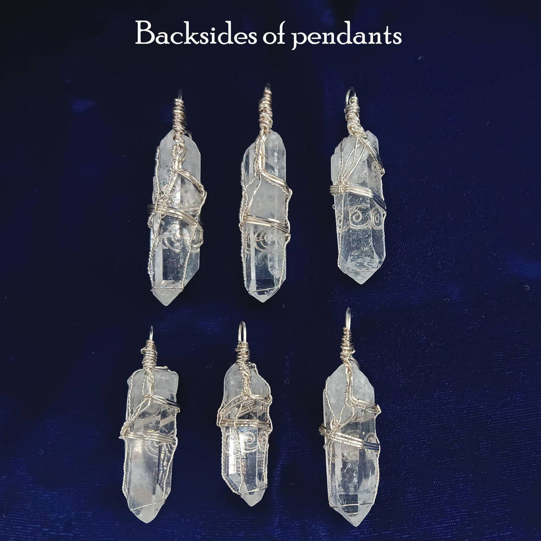 Sea Dragon Dreams raw clear quartz crystal pendants with silver-plated wire wrapping shown from the back.