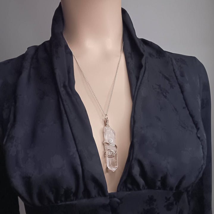 Sea Dragon Dreams raw clear quartz crystal pendant on a silver-plated chain, worn on a mannequin.
