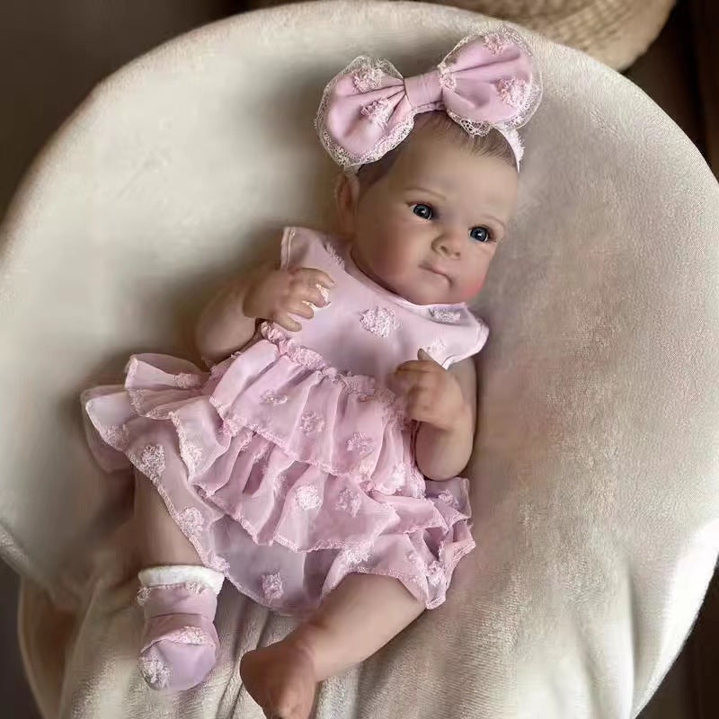 Sea Dragon Dreams 18-inch lifelike reborn baby doll wearing a pink ruffled dress and matching bunny ear headband