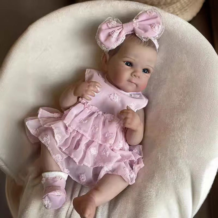 Sea Dragon Dreams 18-inch lifelike reborn baby doll wearing a pink ruffled dress and matching bunny ear headband