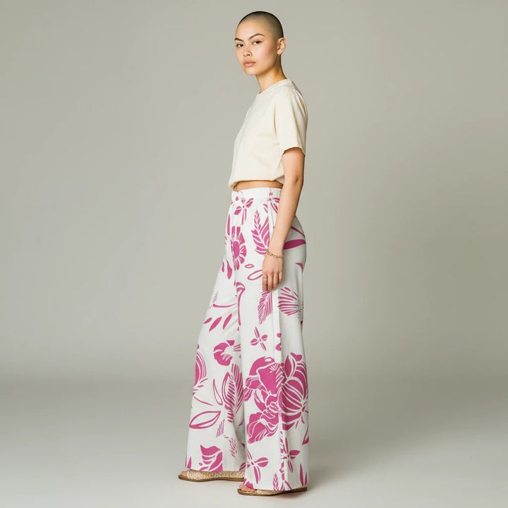 Sea Dragon Dreams women's wide-leg pants featuring a vibrant red floral print on white lightweight polyester fabric.