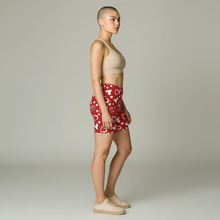 Sea Dragon Dreams high-waisted red biker shorts with white heart pattern worn by a model in a side profile view.