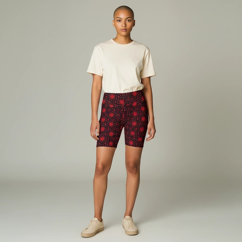 Model wearing Sea Dragon Dreams red spiral star print workout shorts with a cream t-shirt and sneakers