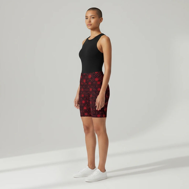 Model wearing Sea Dragon Dreams red spiral star print workout shorts with a black tank top and white sneakers