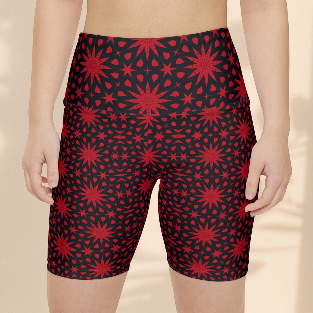 Sea Dragon Dreams red and black spiral star print workout shorts on a model, featuring a high-waisted athletic fit.