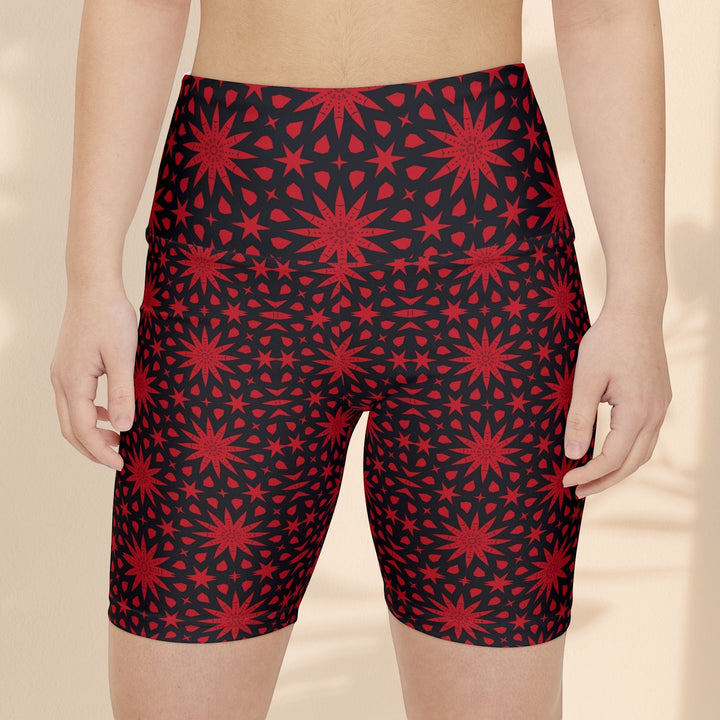 Sea Dragon Dreams red and black spiral star print workout shorts on a model, featuring a high-waisted athletic fit.